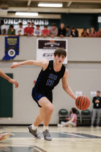 An athlete runs across a basketball court during a game with a Wilson brand basketball. This is also the brand that the National Basketball Association uses (NBA).